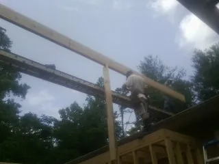 Carpenter setting a ridge beam over a new addition frame — Ice Dam Removal by Roofing Brothers in Smithtown