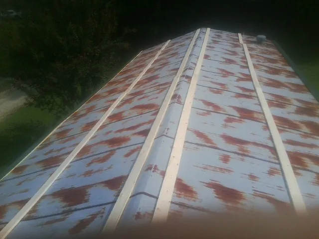 Rusted metal roof panels with new wood purlins before replacement — Storm Damage Roof Repair in Smithtown by Roofing Brothers