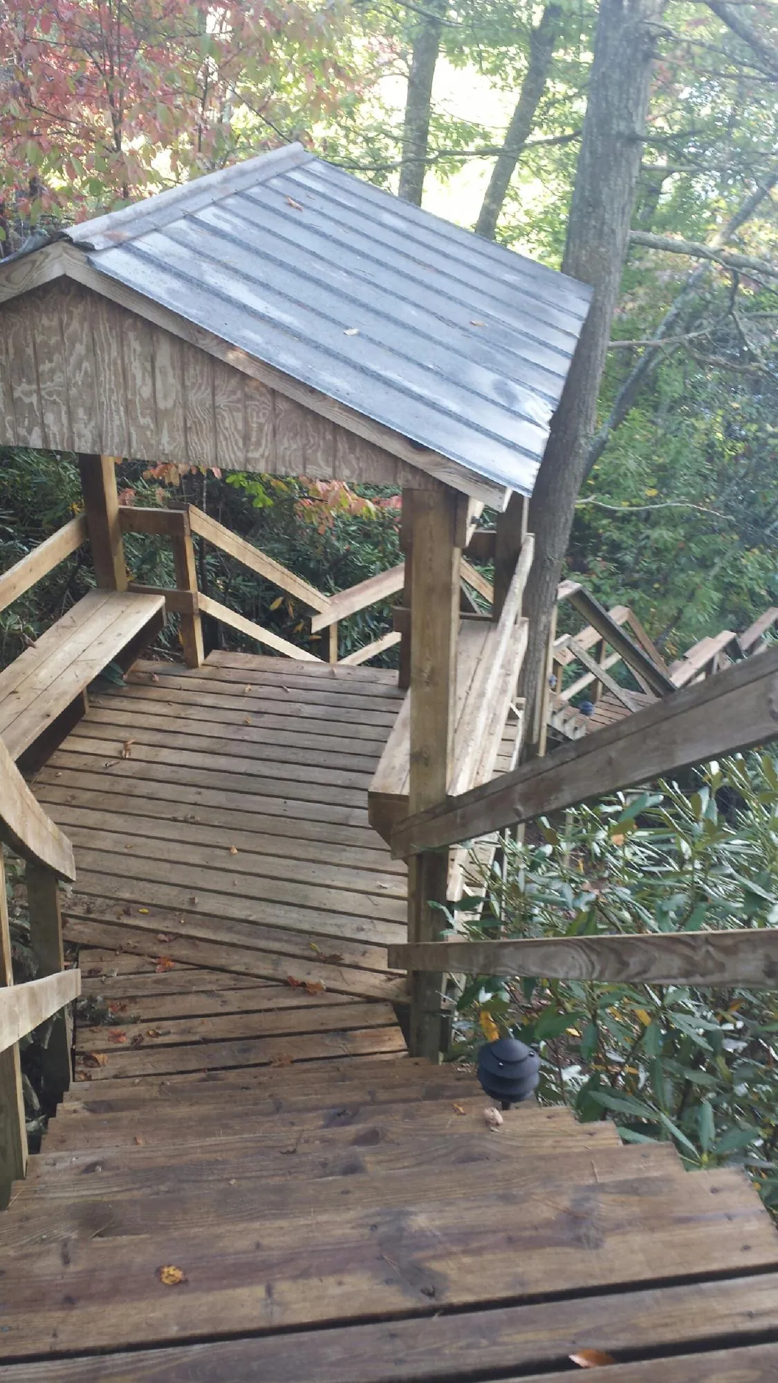 Metal roofed shelter over wooden steps on a wooded walkway — Skylight Repair & Installation work by our crew in Smithtown