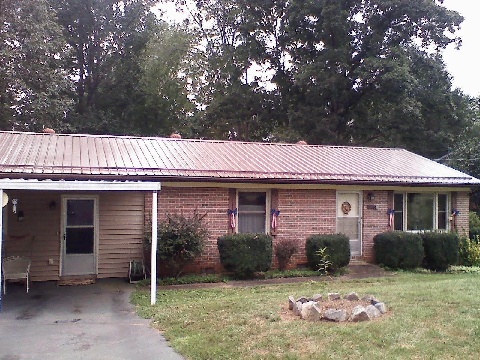 Bronze metal roof and carport on a brick ranch home — Roof Repair work by our crew in Smithtown